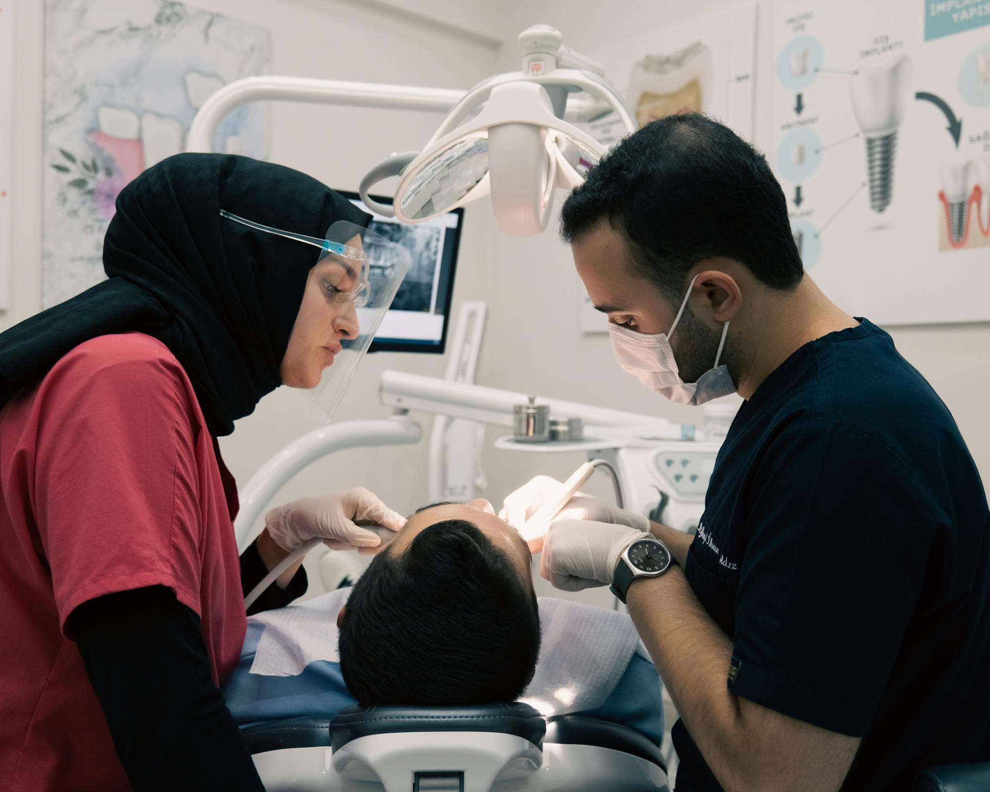 A dental team working with a patient in a modern operatory